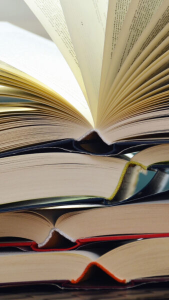 Nahaufnahme aufgeschlagener Bücher mit rotem, grünen und blauem Einband