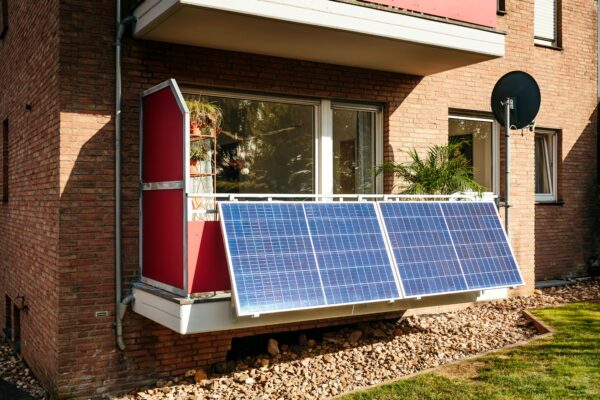 Balkon einer Erdgeschosswohnung eines Klinker-Mehrfamilienhauses mit vier Solarmodulen
